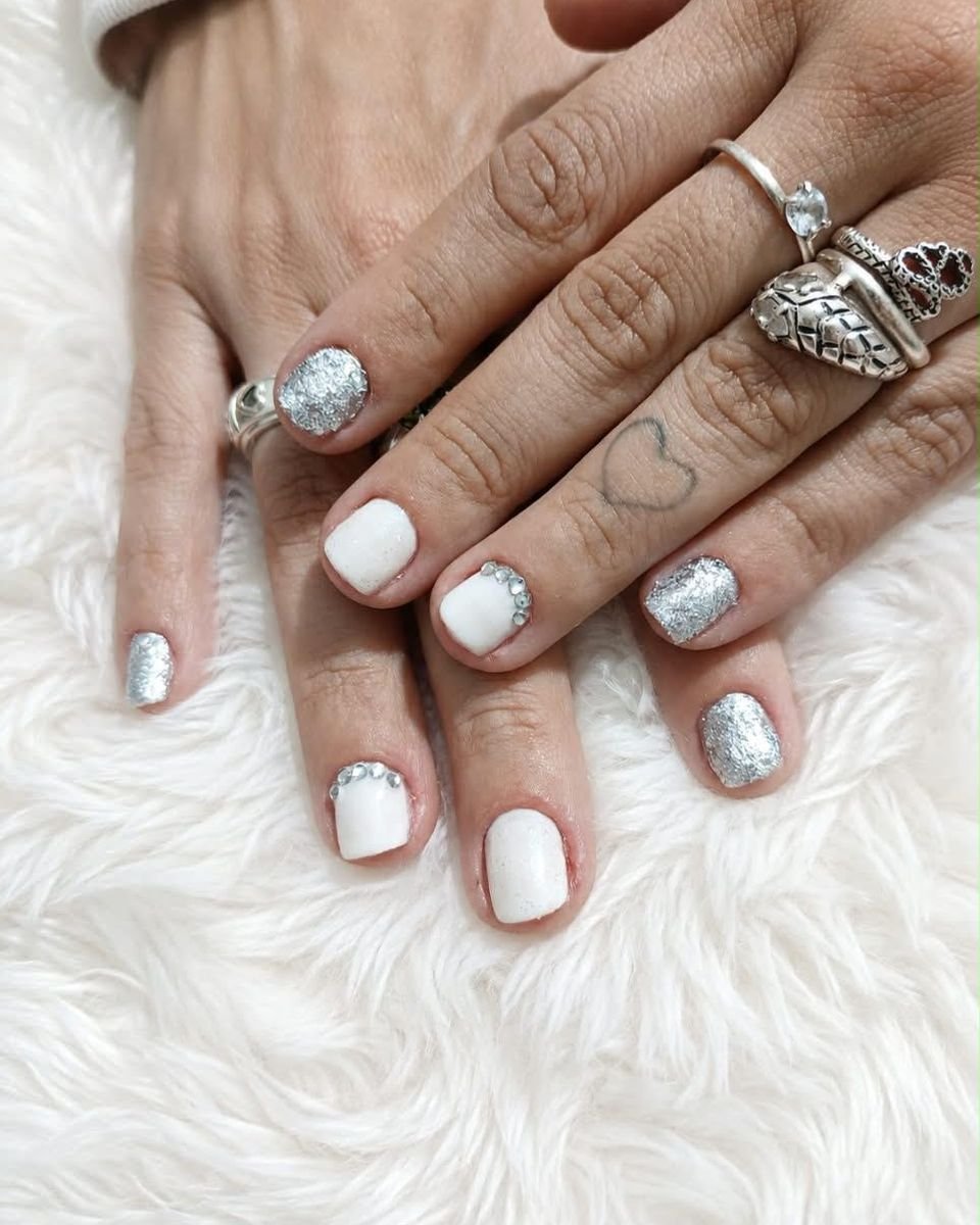 Unhas brancas combinadas com glitter prateado